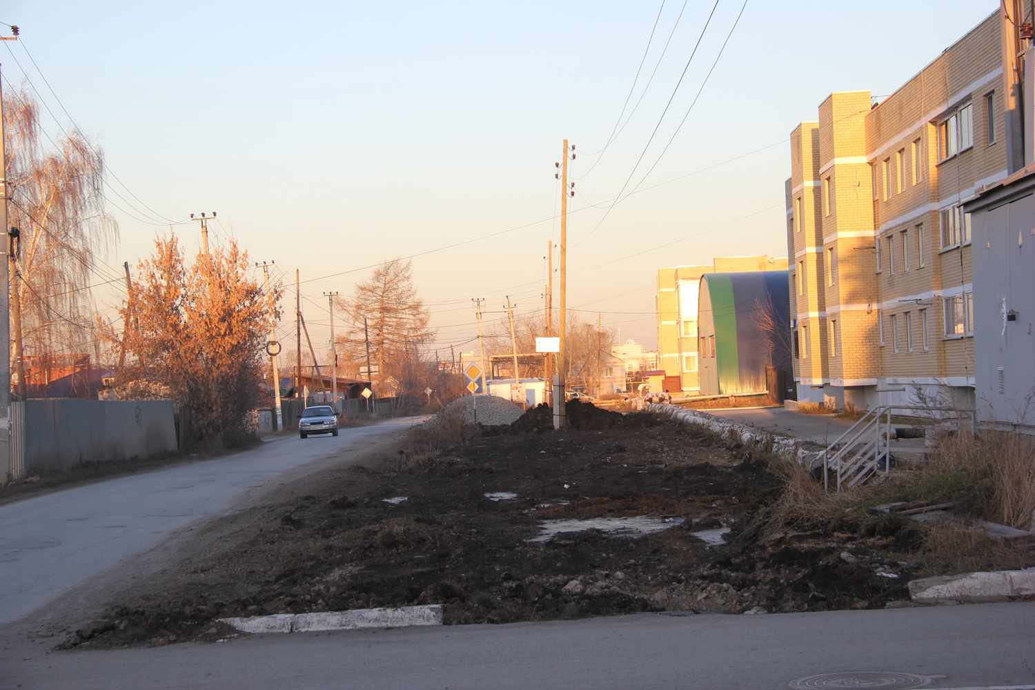 В Арамиле у дома по ул. Красноармейской делают парковку на месте «убитых» газона и обочины, но жителям первых этажей теперь не позавидуешь…